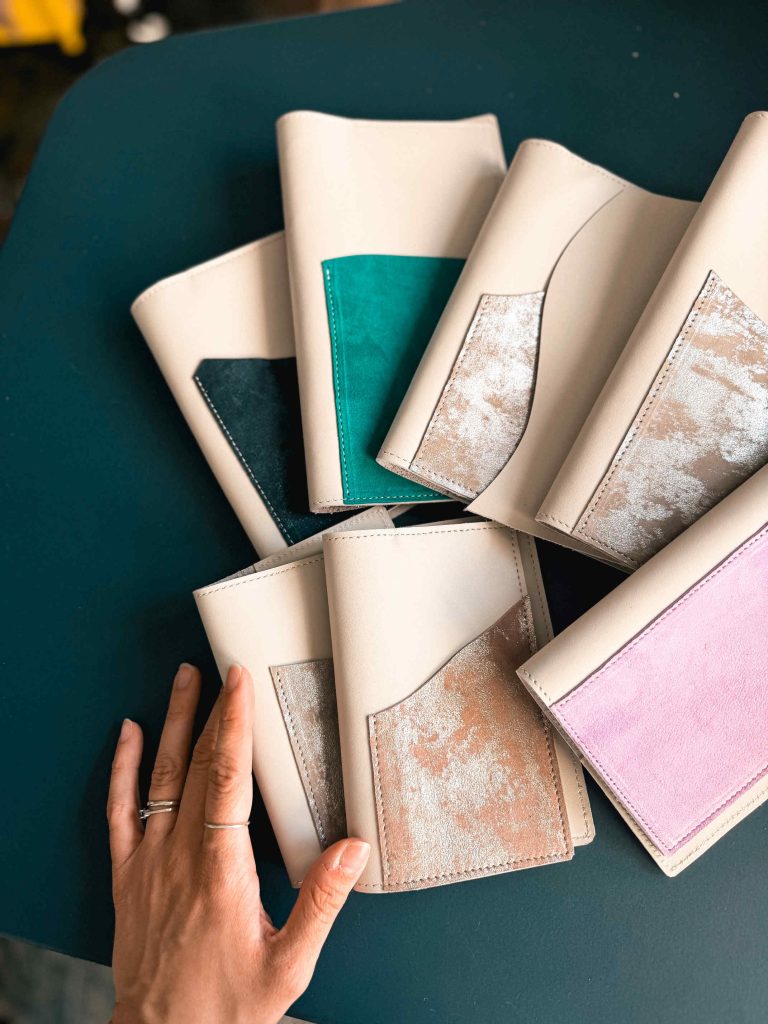 Leather covers with different outside pocket, hand holding them on the table
